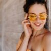 kobieta w okrągłych okularach przeciwsłonecznych z pomarańczowymi szkłami