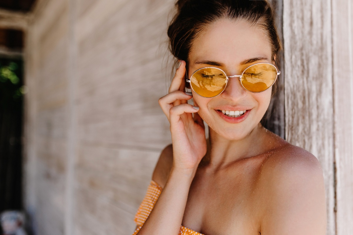 kobieta w okrągłych okularach przeciwsłonecznych z pomarańczowymi szkłami